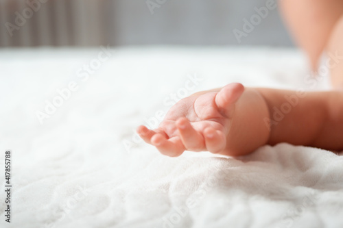 Mother's Day concept. Baby's hand close-up, on a white sheet