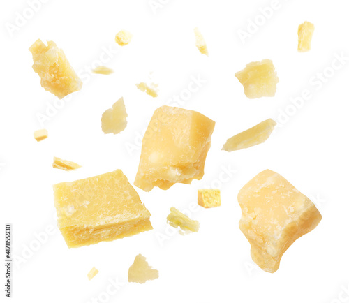 Pieces of delicious parmesan cheese flying on white background photo