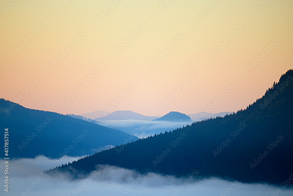 Abstract photo. The peaks of the mountains in the fog in the dawn haze. Vintage hipster abstract background. Abstract photo. The peaks of the mountains in the fog in the dawn haze. Vintage hipster abstract background.