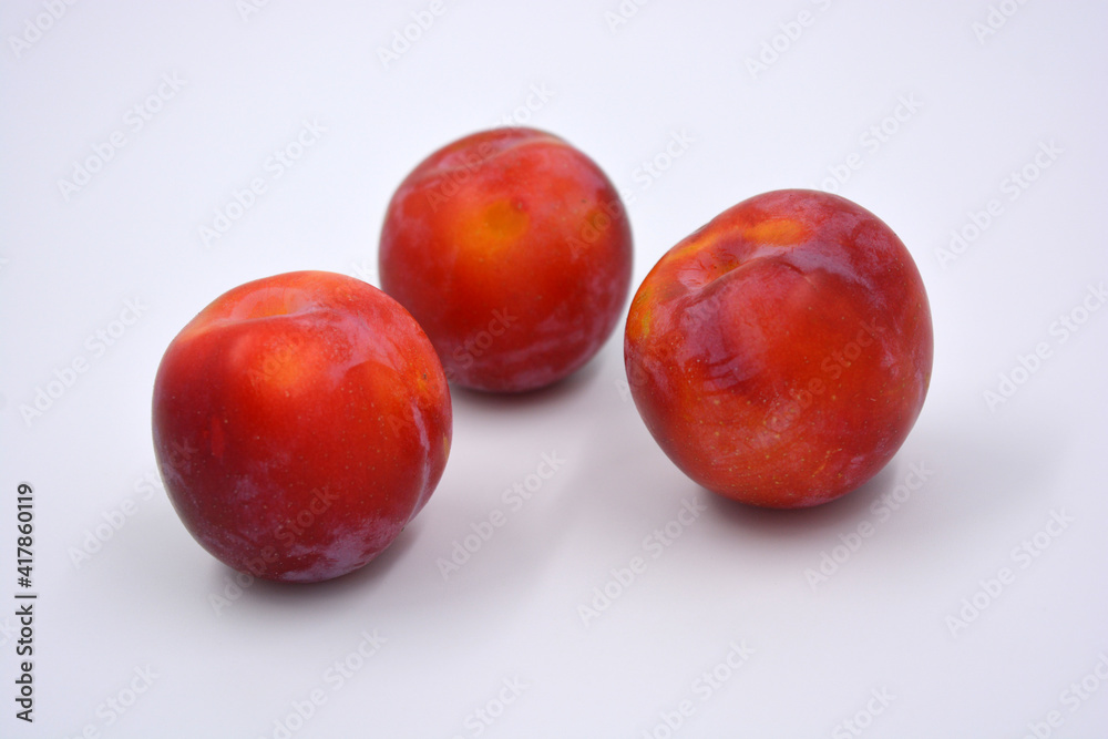 Delicious useful fruits, red, cherry ripe plums located on a white background. Delicious useful fruits, red, cherry ripe plums located on a white background.