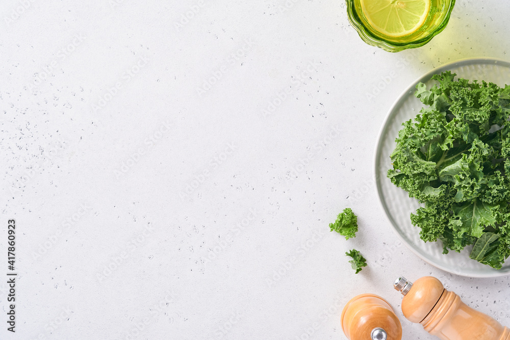 Bowl of fresh green chopped kale on light gray stone background, top view. Ingredient for making healthy salad. Clean eating, detox or diet concept. Mock up. Bowl of fresh green chopped kale on light gray stone background, top view. Ingredient for making healthy salad. Clean eating, detox or diet concept. Mock up.