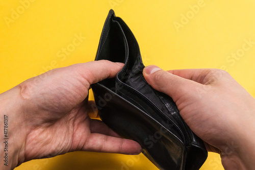 open an empty wallet at the end of the month. on a yellow background is the time to earn, selective focus
