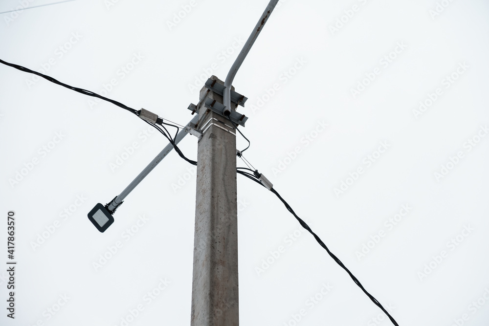 An electric pole against a clear gray sky. An electric pole against a clear gray sky.