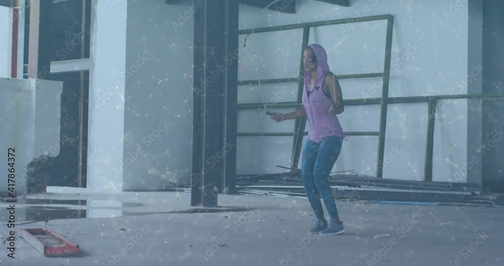 Animation of network of connections over woman jumping the rope in an abandoned building Animation of network of connections over woman jumping the rope in an abandoned building