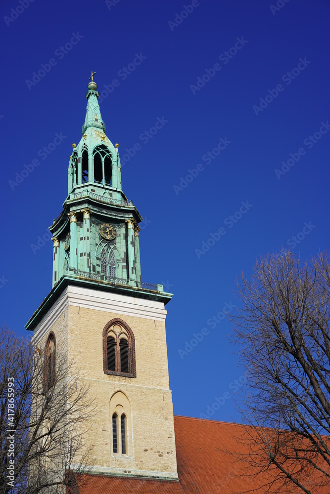 Historische, sehenswerte Kirche in Berlin, die St. Marienkirche am Alexanderplatz bei Sonnenschein und blauem Himmel