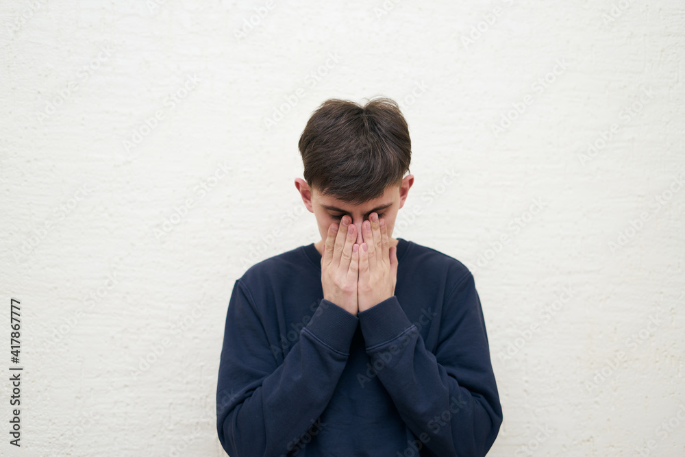 cover his face with his hands, portrait of young pensive man cover his face with his hands, portrait of young pensive man