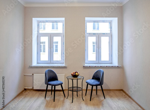 Modern interior design concept. Minimalistic style. Two blue armchairs and a table with fruit.