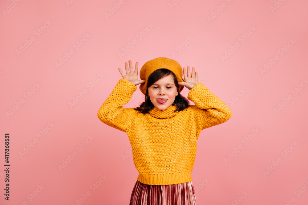 Positive kid making funny faces. Studio shot of caucasian child posing on pastel background. Positive kid making funny faces. Studio shot of caucasian child posing on pastel background.