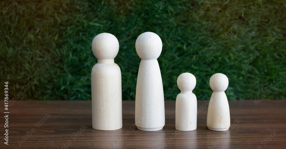 Family wooden figure put on board,in front green grass background, Family wooden figure put on board,in front green grass background,