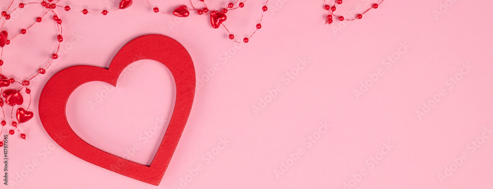 Red heart with beads with hearts on pastel pink colors. Valentine's Day background. Valentine's Day concept. Flat lay. Top view. Red heart with beads with hearts on pastel pink colors. Valentine's Day background. Valentine's Day concept. Flat lay. Top view.