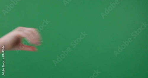 Woman hand sign flicking off over green background