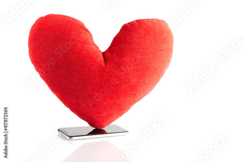 Big red toy heart at smart phone like symbol icon followers from social network isolated on white background. Social media concept. © Naz