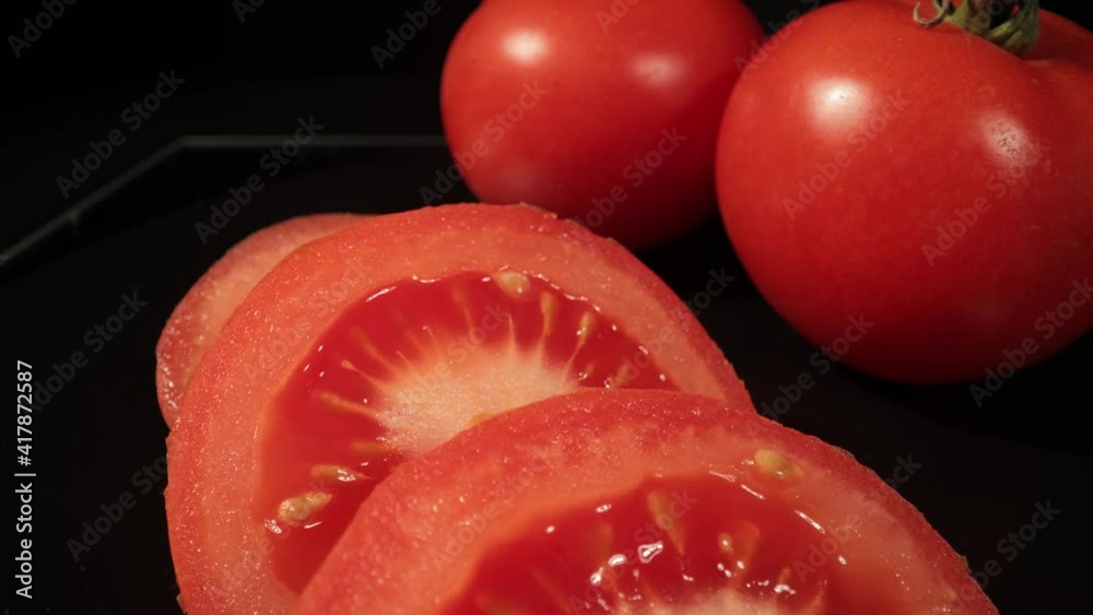 Cut fresh tomatoes into slices - macro shot Cut fresh tomatoes into slices - macro shot