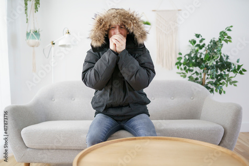 Fotografiet Man With Warm Clothing Feeling The Cold Inside House on the sofa