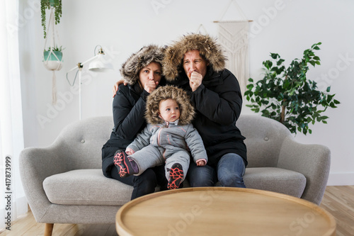 Couple have cold on the sofa at home with winter coat with baby Fototapet