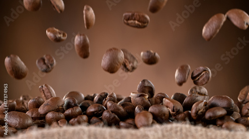 Falling Roasted Coffee Beans into Jute Bag  close-up.
