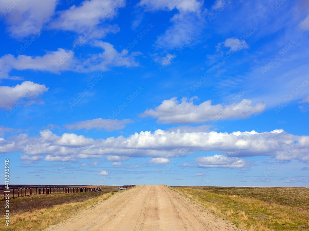Beautiful summer road and white clouds in the tundra Beautiful summer road and white clouds in the tundra