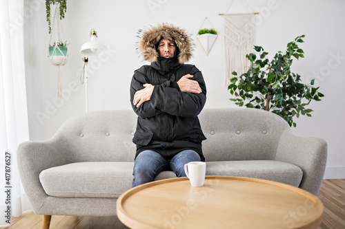 Fototapeta Man With Warm Clothing Feeling The Cold Inside House on the sofa