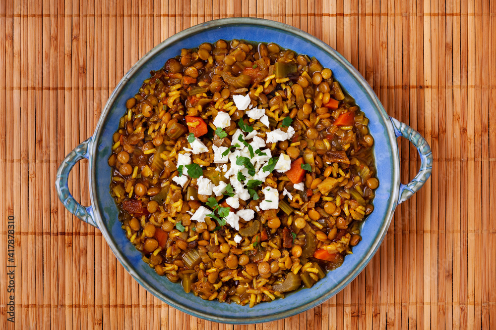 Green lentil soup dish flat lay. Lentil soup with rice, carrot and celery in a plate.