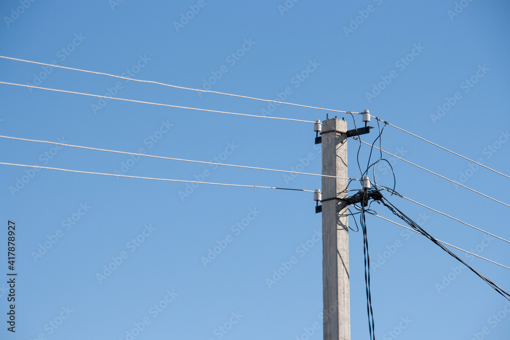 Power line post with with white insulators and wires on a background of blue sky Power line post with with white insulators and wires on a background of blue sky