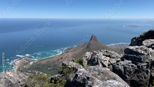 Table Mountain top granite rocks with views of Clifton beach , Lions Head and Robben Island on the deep Atlantic Ocean of the Cape Peninsula