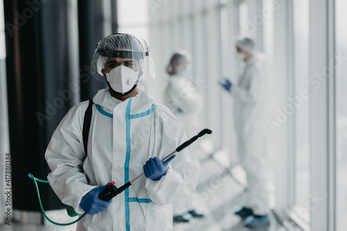 Portrait of doctor in white safety protective uniform ready desinfect covid-19 contamination epidemic in hospital area photo