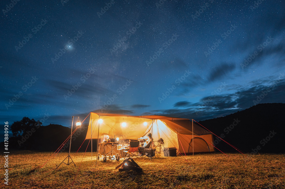 Tourists in yellow tent camping on hill with milky way in the night sky - obrazy, fototapety, plakaty 