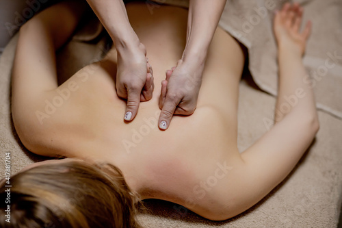 Body care. Young girl having massage  relaxing in spa salon  closeup