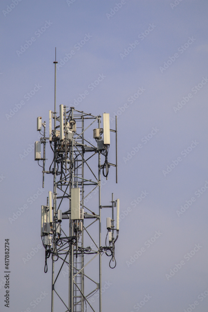 5G telecommunication tower 5G mobile phone wireless antenna machine Located in the center of the city against a blue sky background. 5G telecommunication tower 5G mobile phone wireless antenna machine Located in the center of the city against a blue sky background.