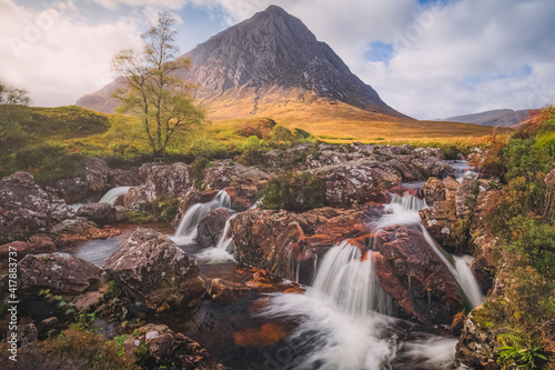 Dramatic mountain landscape of the iconic Buachaille Etive Mor and River Coupall waterfall at Glencoe in the Scottish Highlands, Scotland.