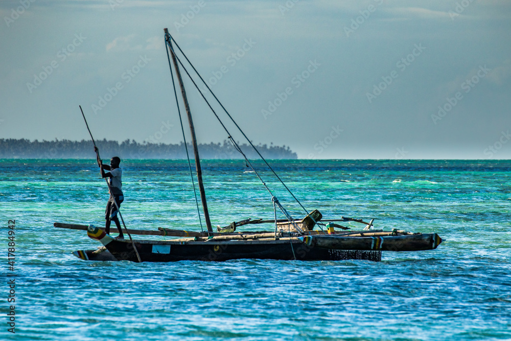Naklejka premium Jambaini, Zanzibar, A traditional native nagalawa with sail down. The ngalawa or ungalawa is a traditional, double-outrigger canoe of the Swahili people living in Zanzibar