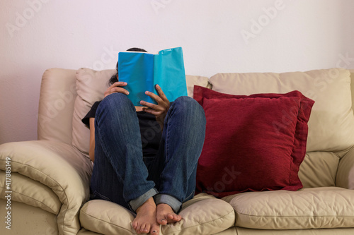 a girl enjoying a book on a sofa