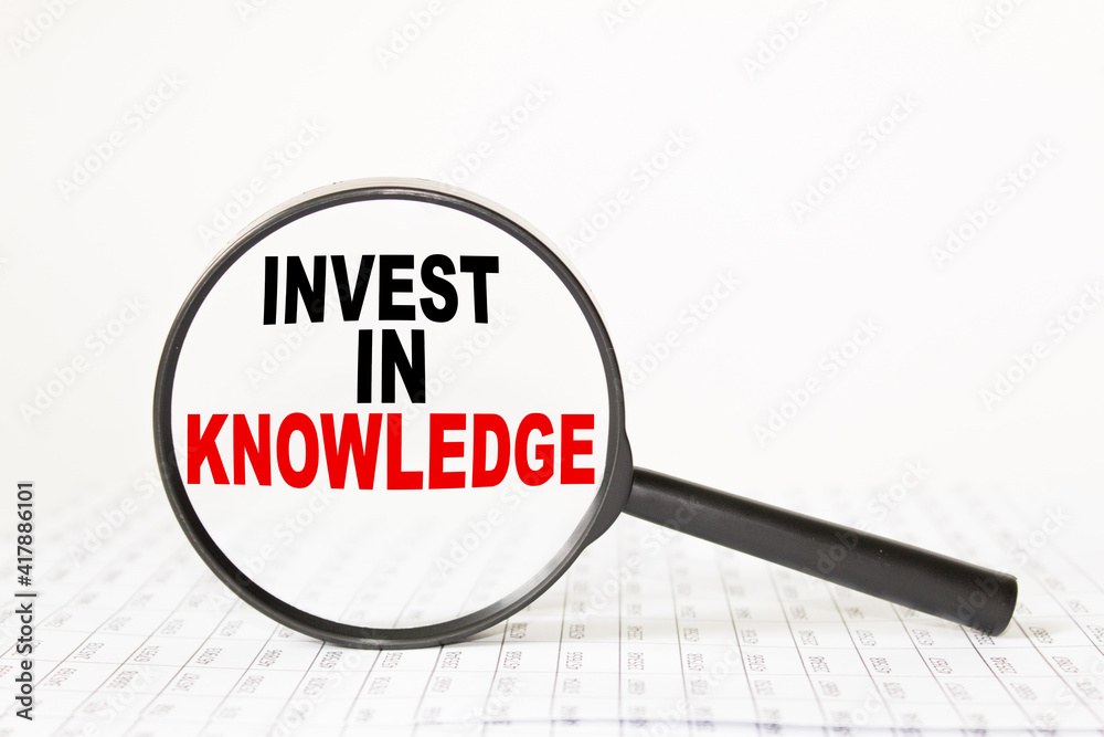 words INVEST IN KNOWLEDGE in a magnifying glass on a white background. business concept words INVEST IN KNOWLEDGE in a magnifying glass on a white background. business concept