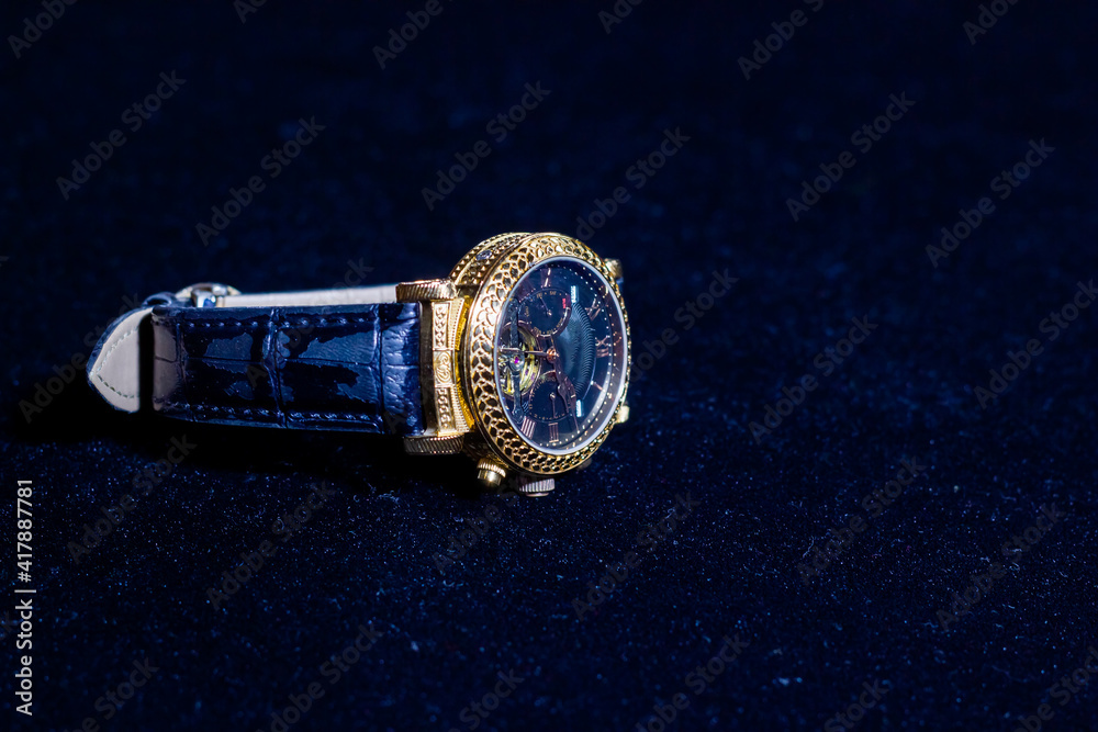 old watch, retro watch on dark blue background, watch in the dark, golden watch on blue