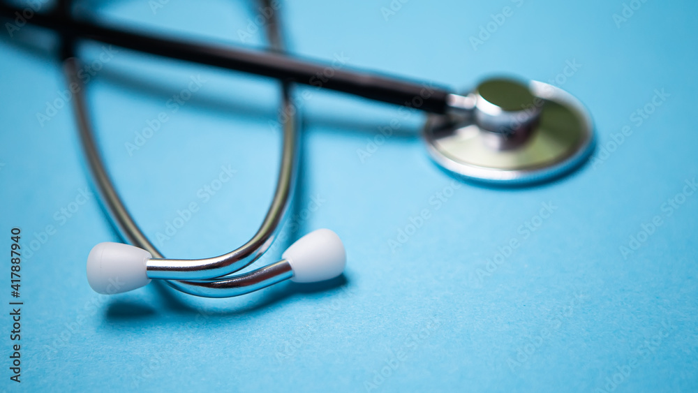 Close up black modern stethoscope with reflection on blue background with copy free space for message. Medical nurse or doctor equipment object. Medicine healthcare concept. Close up black modern stethoscope with reflection on blue background with copy free space for message. Medical nurse or doctor equipment object. Medicine healthcare concept.