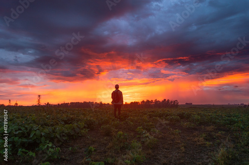 Hombre en medio del campo con amanecer.