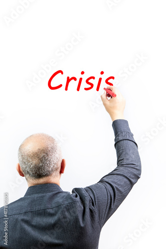 Executive writing the word crisis in red on a white background