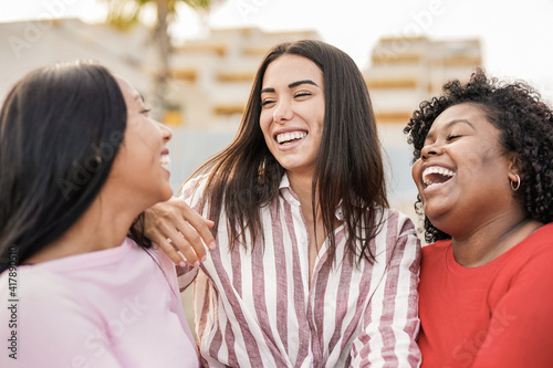 Cheerful  multiracial women laughing outdoor - Young people enjoy time together in the city together - Concept of travel and happiness photo