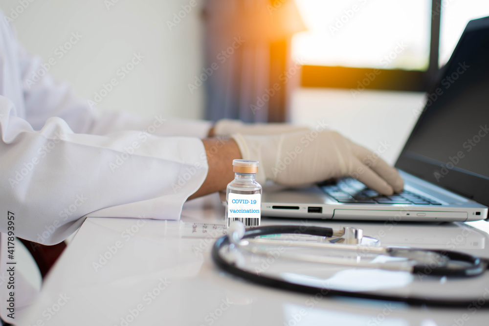 Fototapeta premium The coronavirus vaccine bottles are placed on the table in the lab. A doctor's laboratory concept invented a cure for coronavirus disease (COVID-19). Closeup. Selective focus. Blurred background.