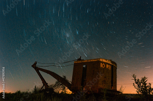 Maquina vieja en noche estrellada, larga exposición.