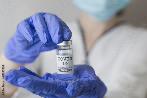 Female doctor holding syringe and COVID-19 vaccine. Healthcare And Medical concept.