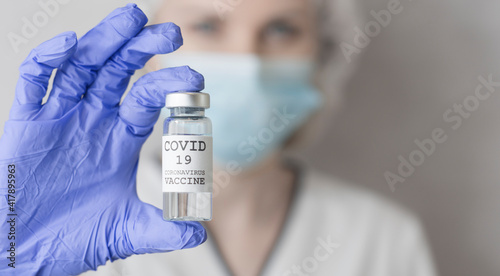 Female doctor holding syringe and COVID-19 vaccine. Healthcare And Medical concept.