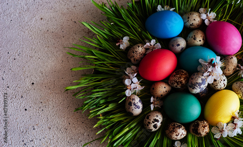 Easter background with Easter eggs and spring grass. Row of easter eggs in fresh green grass. Colorful eggs in nest on meadow.