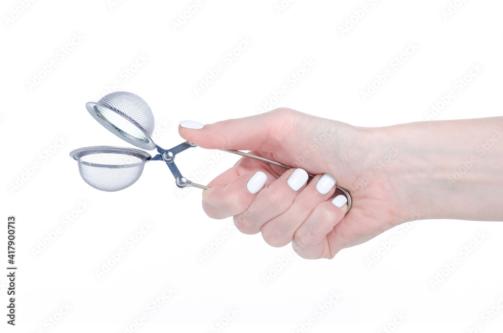 Metal tea strainer in hand on white background isolation Metal tea strainer in hand on white background isolation