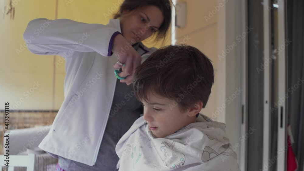 Mother cuts hair of her son at balcony of home, during coronavirus quarantine, low side view, static shot Mother cuts hair of her son at balcony of home, during coronavirus quarantine, low side view, static shot