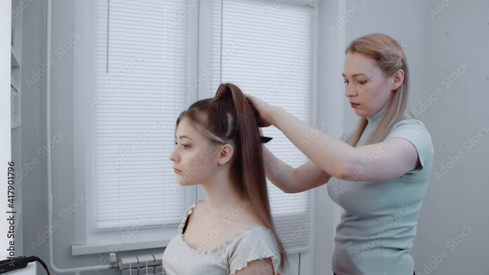 The hairdresser is combing the hair of the model in the beauty salon. Beauty concept. Close-up . The hairdresser is combing the hair of the model in the beauty salon. Beauty concept. Close-up .