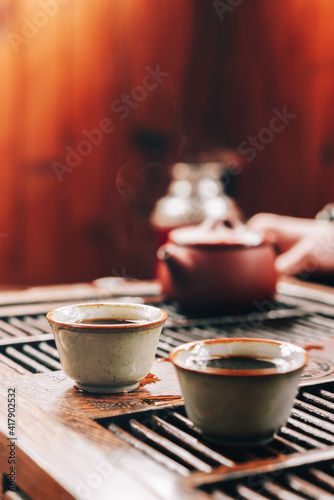 Chinese tea ceremony.Ceramic tea bowl on a wooden chaban.