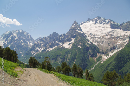 Dombay. Empty dirt road. View from the Mussa-Achitara mountain. Nature and travel. Russia, North Caucasus, Karachay-Cherkessia