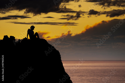 silhouette of people on the beach cliff at sunset