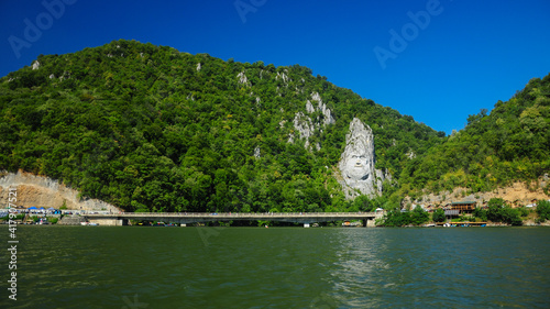 The huge stone carved statue showing the portrait of the ancient dacian king: Decebal. The sculpture is located on the shore of Danube River, Eselnita, Romania  photo